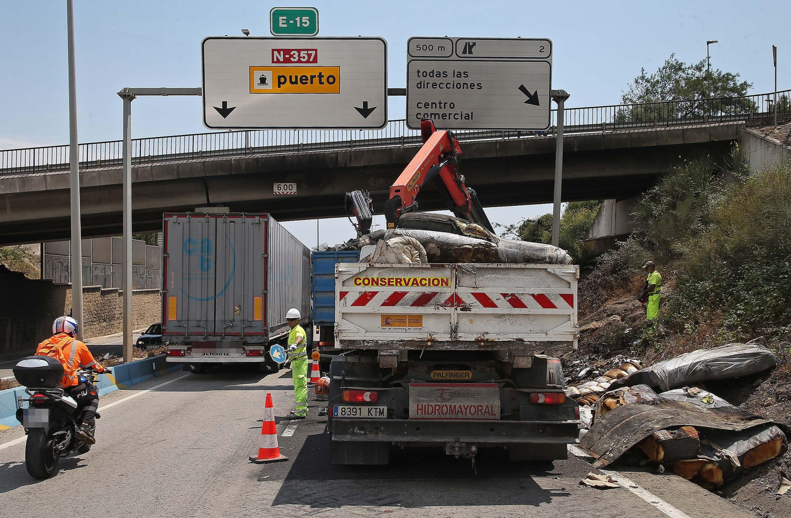 Fotos de la retirada de la carga del camión incendiado en el acceso norte de Algeciras