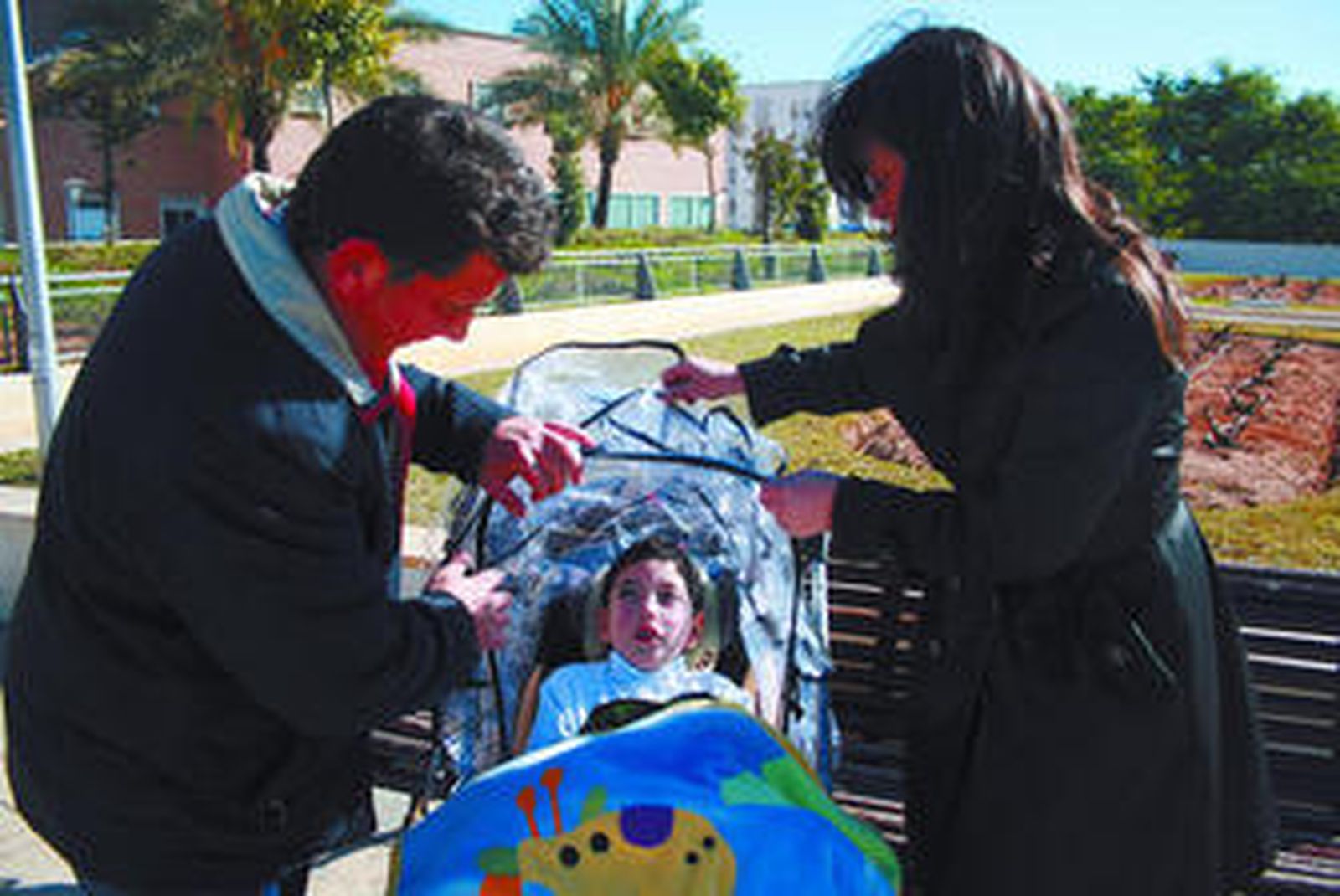 Joaquín, junto a su madre Fali y su padre Jesús tras la visita al neuropediatra en el Hospital Virgen del Rocío.