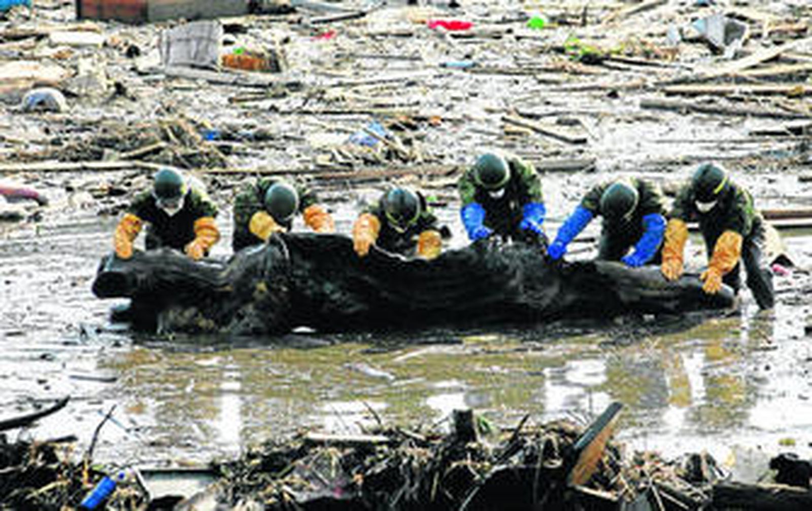 Militares japoneses buscán cadáveres entre los millones de toneladas de escombros producidos por el 'tsunami'.