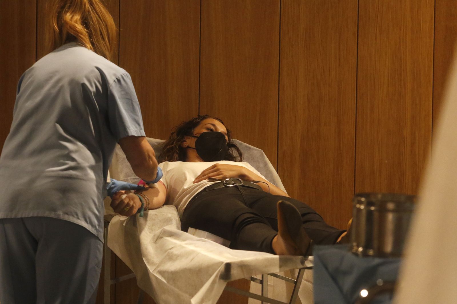 Una enfermera prepara a una mujer para donar sangre.