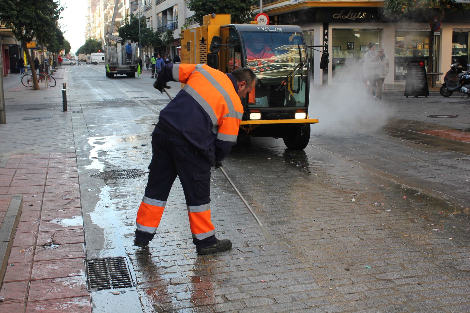 Un operario de Lipasam retira con una rasqueta los restos de caramelos en Asunción.