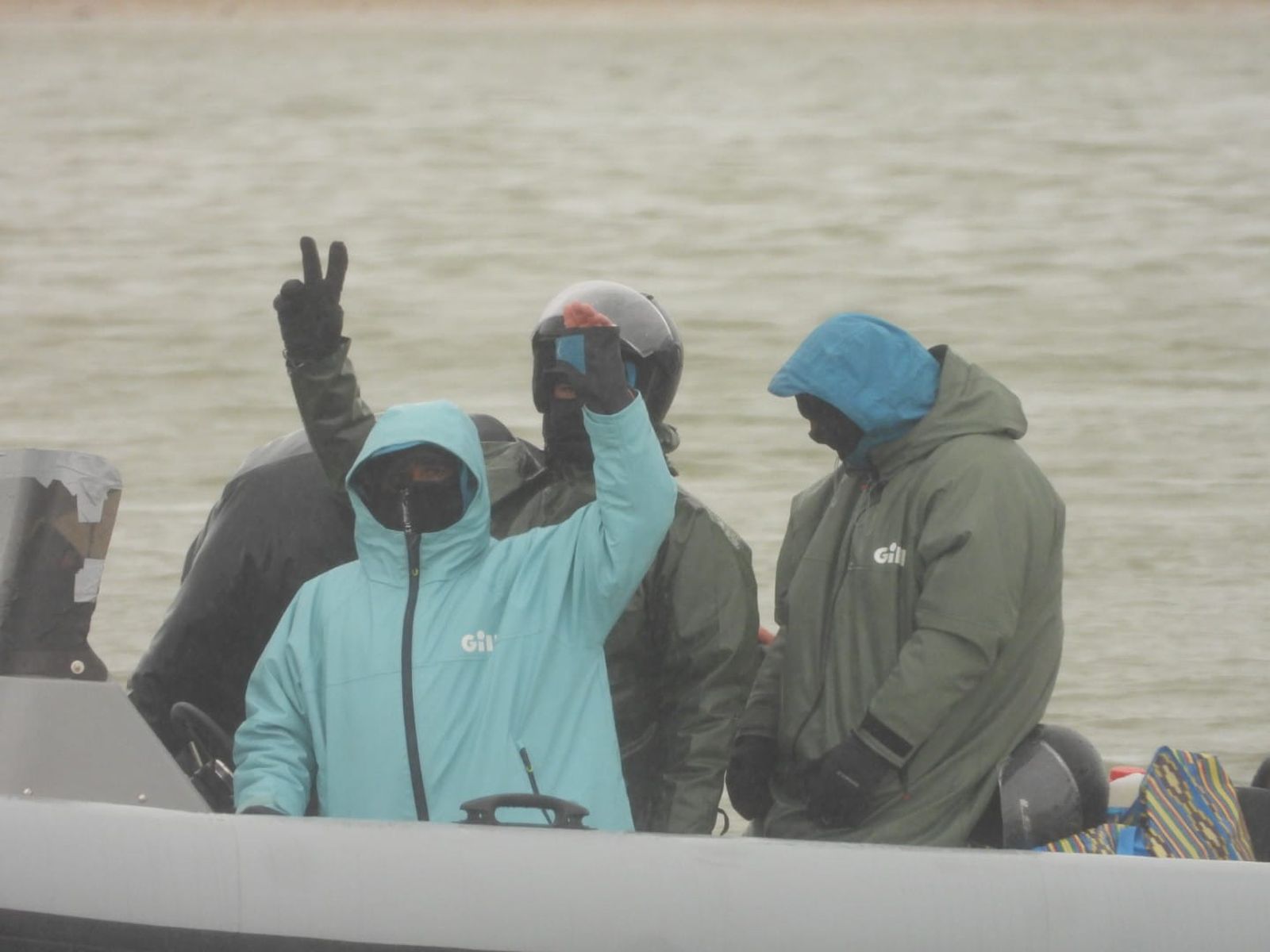 Narcos haciendo gestos a la guardia civil desde una goma este viernes en Sancti Petri.