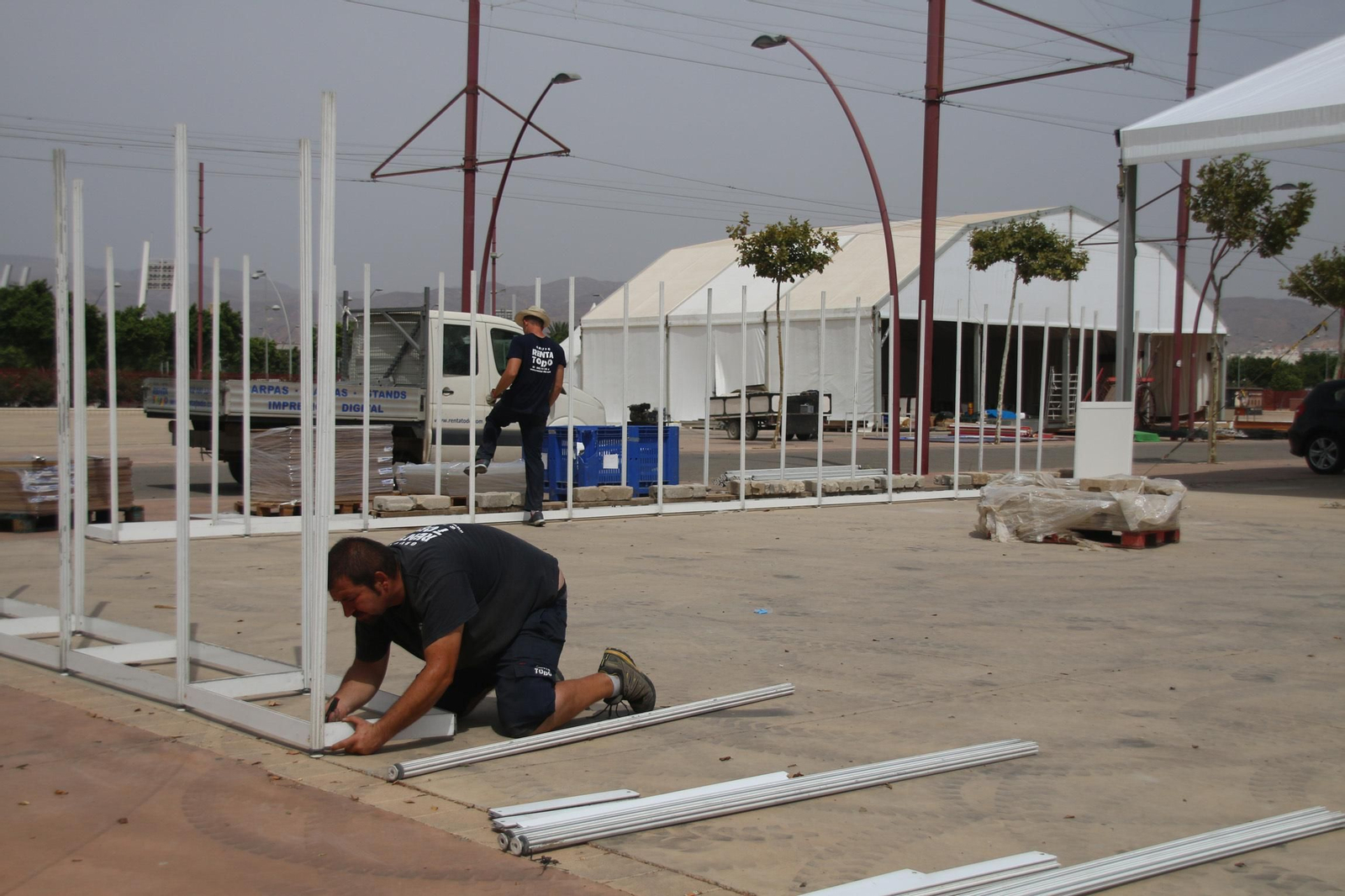 Operarios afanados en el montaje de las casetas que darán vida al recinto.