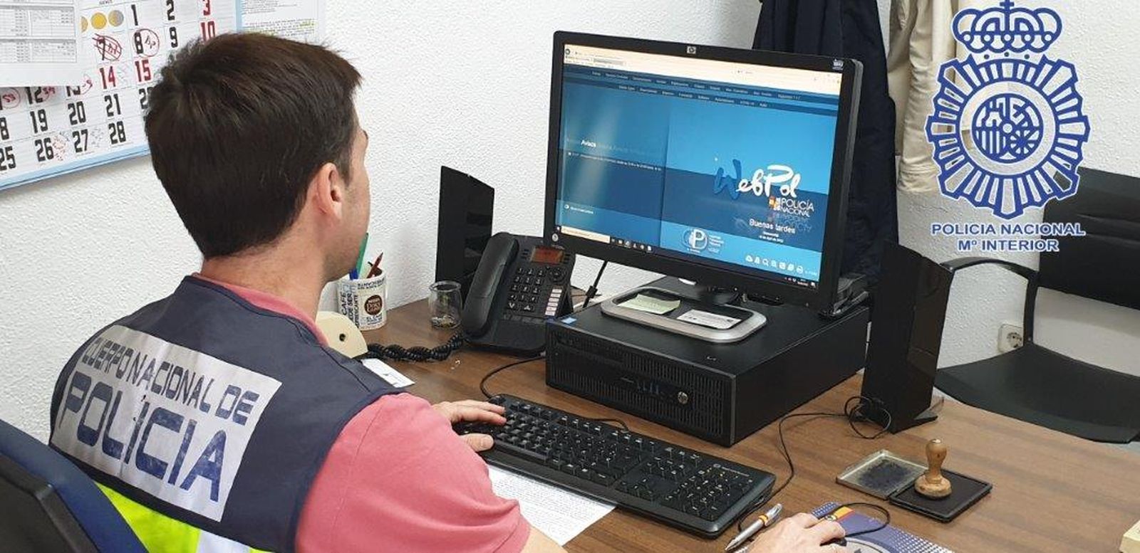Un policía nacional trabaja en un ordenador.