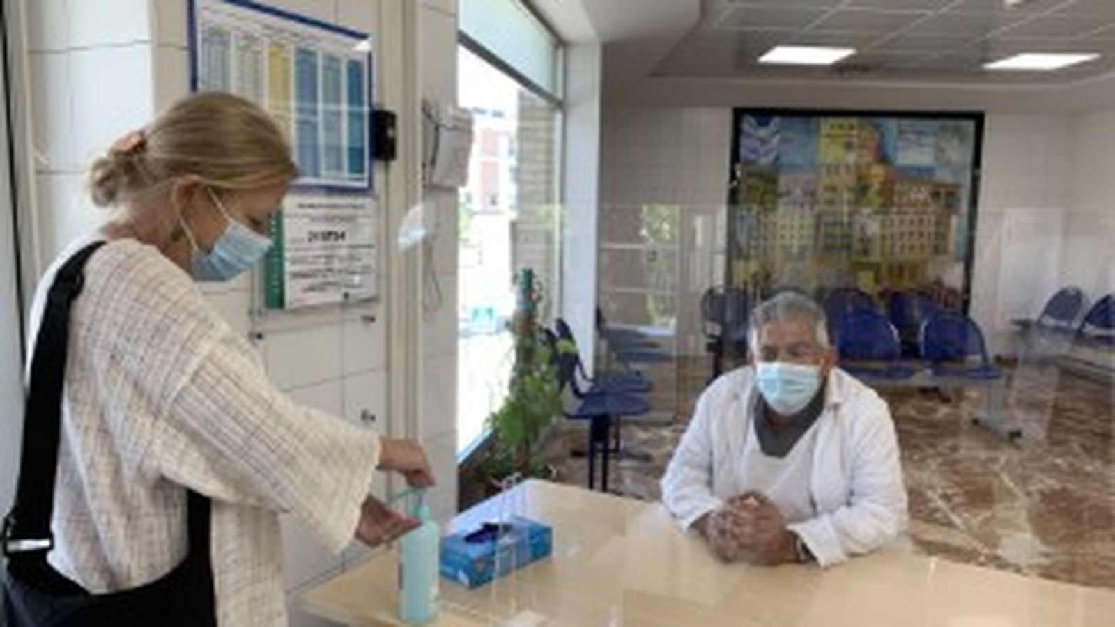 Un profesional tras una mampara de metacrilato en el Hospital Regional.