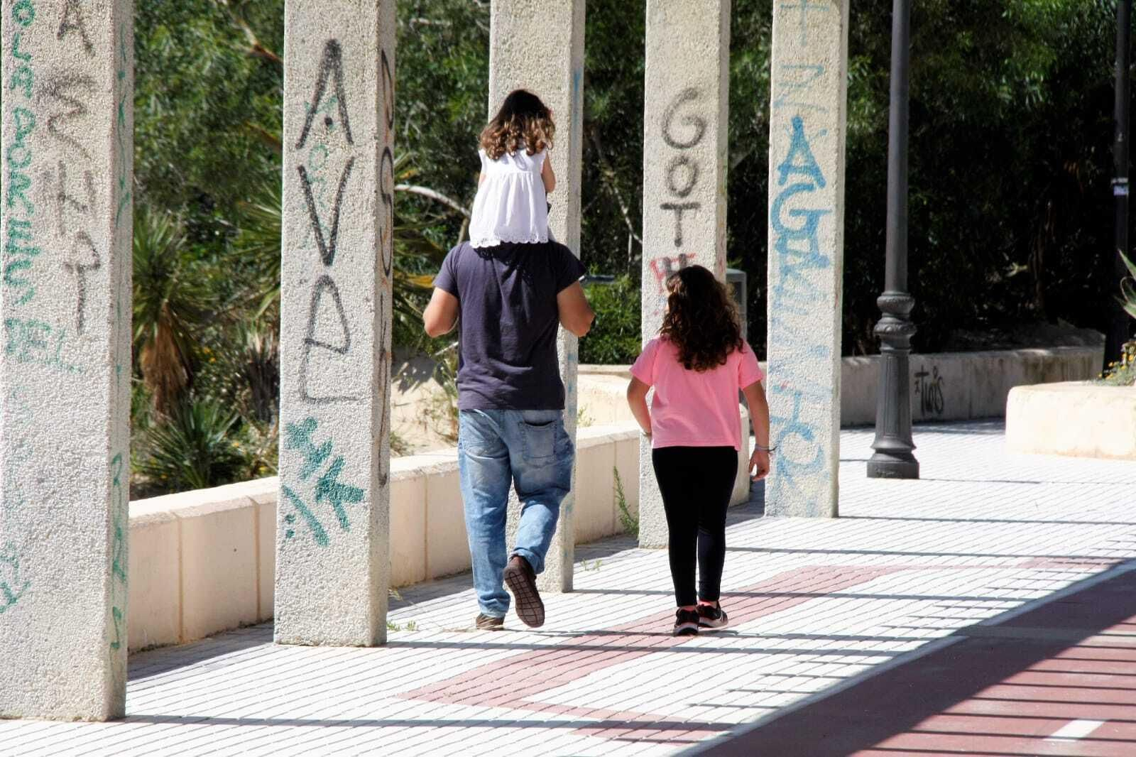 Un padre con sus hijas, este viernes en el paseo marítimo de la Puntilla.
