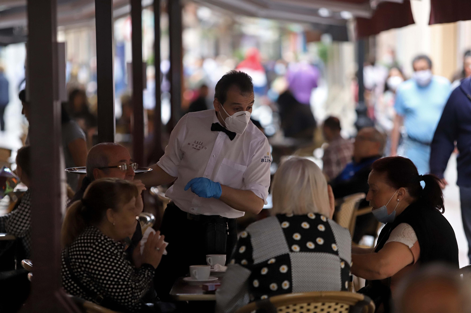 Varias personas toman un café en la calle Real de La Línea