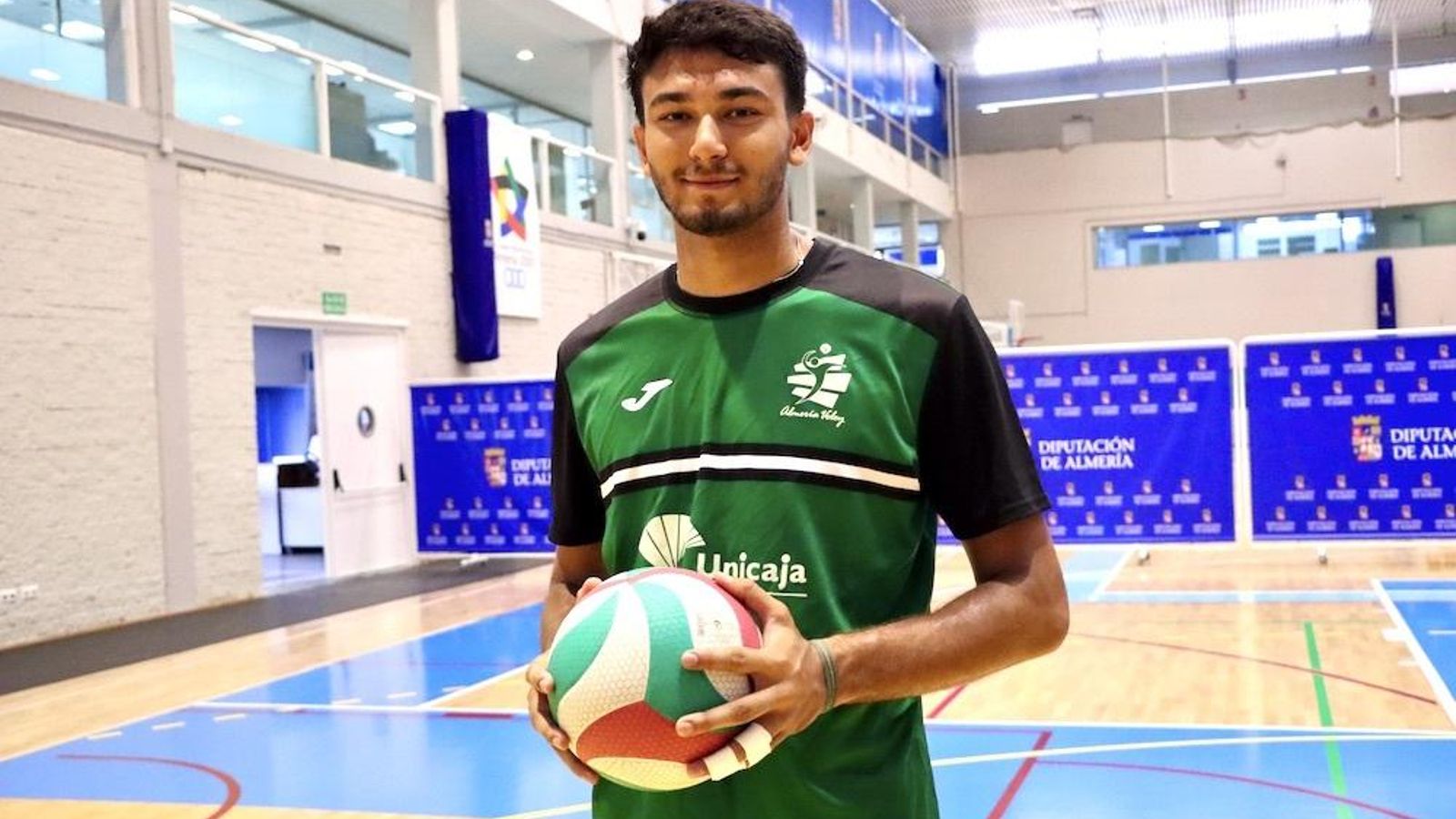 Álvaro Viera posa con un balón de voleibol con la ropa de entrenamiento del conjunto verde.