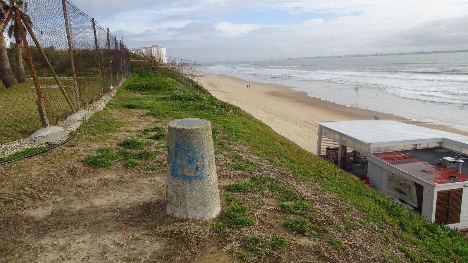 Uno de los hitos de piedra que marcan la servidumbre de paso junto al litoral.