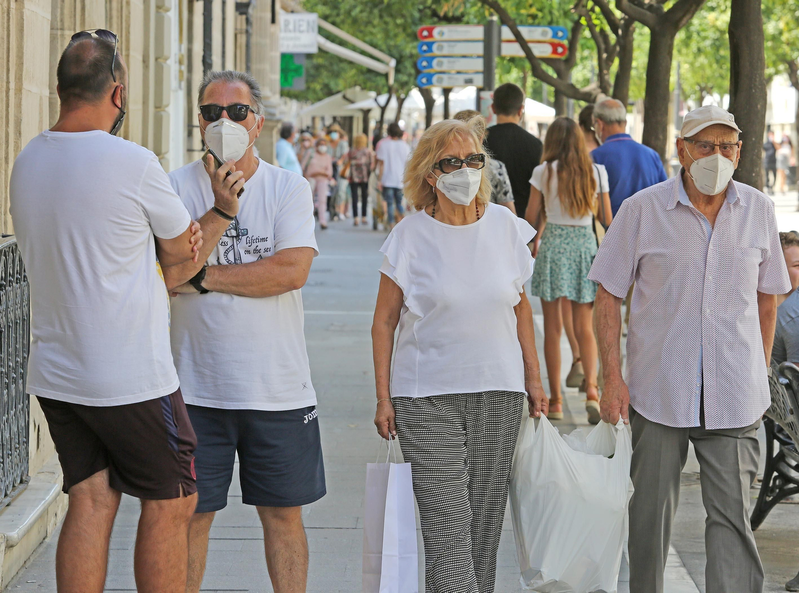Transeúntes por la calle Larga con mascarilla.