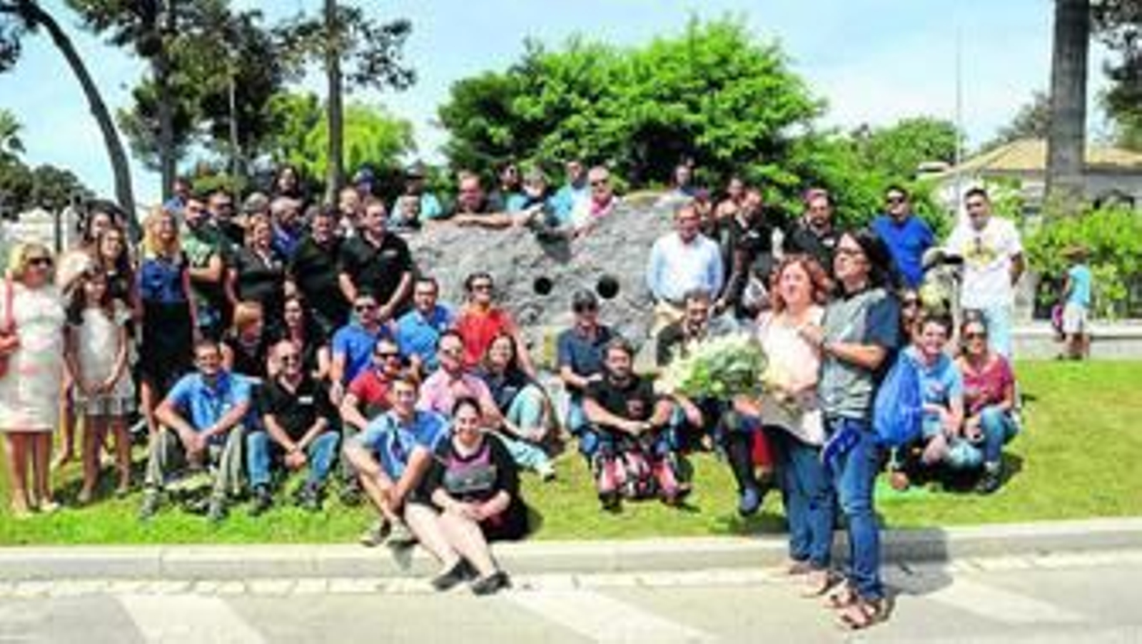Los moteros y familiares posan, a su llegada final a Jerez, junto a la escultura en memoria de las víctimas.