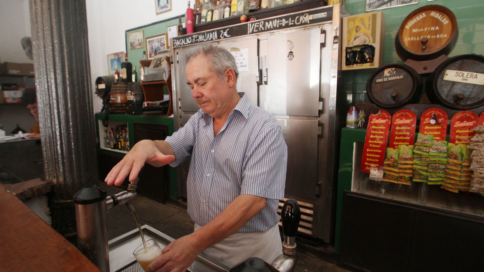 Un camarero tira una cerveza con la inclinación para la espuma