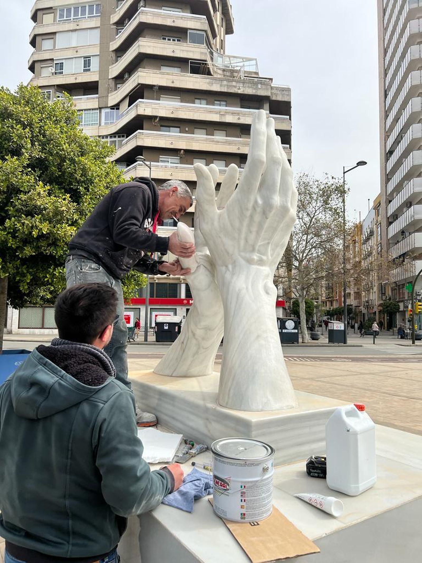 Operarios reparan la escultura dedicada a los sanitarios.