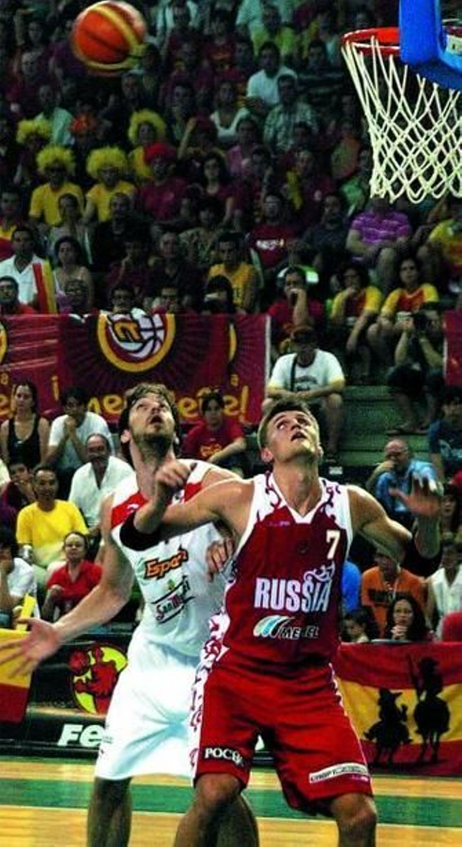 Pau Gasol y Kirilenko tratan de ganar la posición para coger el rebote.