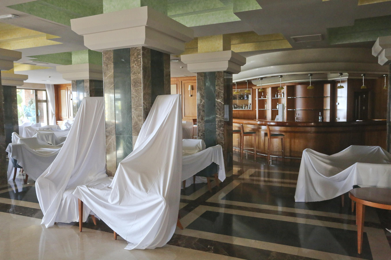 Sábanas blancas visten el hotel Amaragua de Torremolinos, cerrado por el coronavirus, en fotos