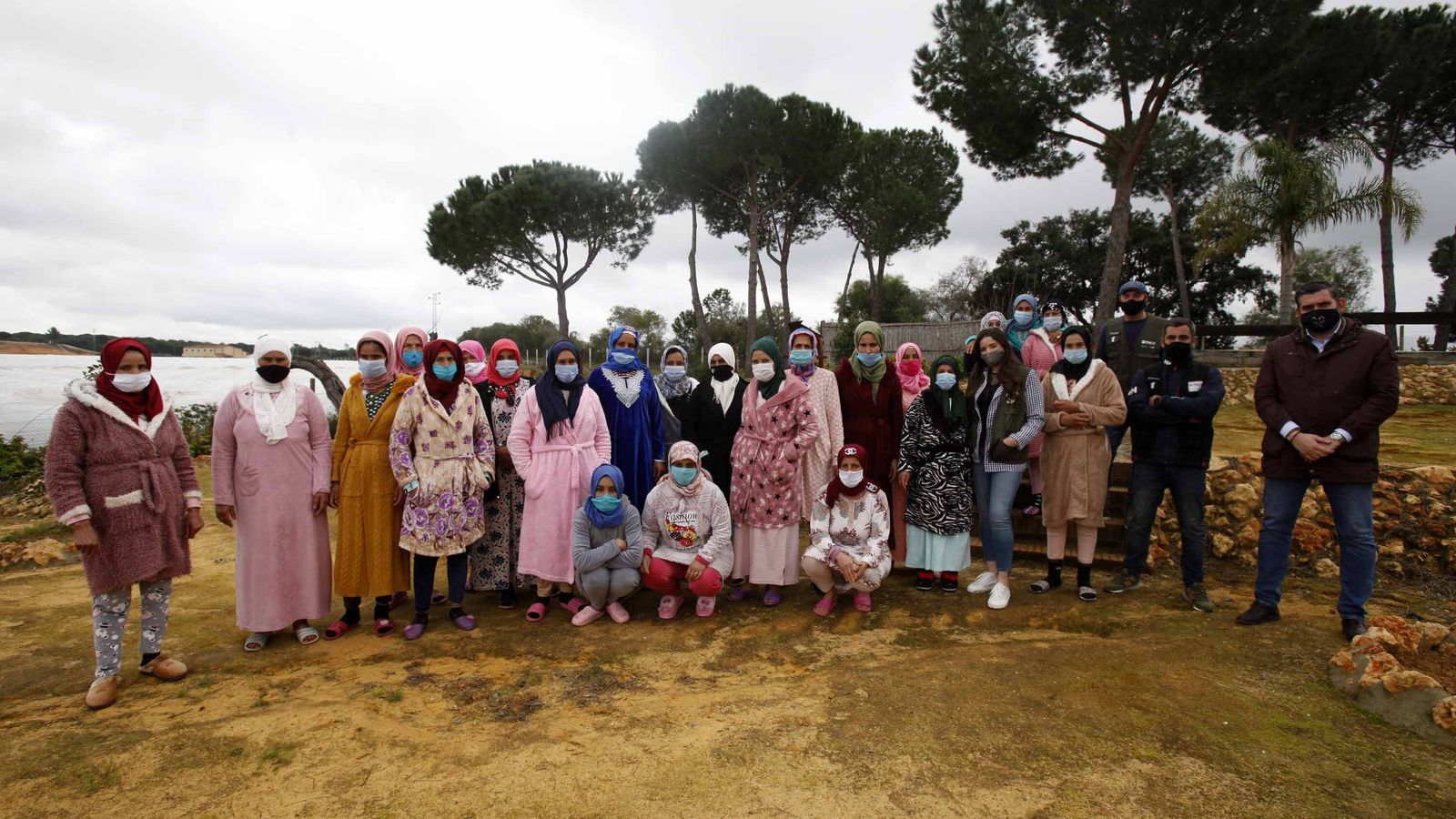 Responsables de Interfresa y del Prelsi con un grupo de temporeras en una finca de Huelva