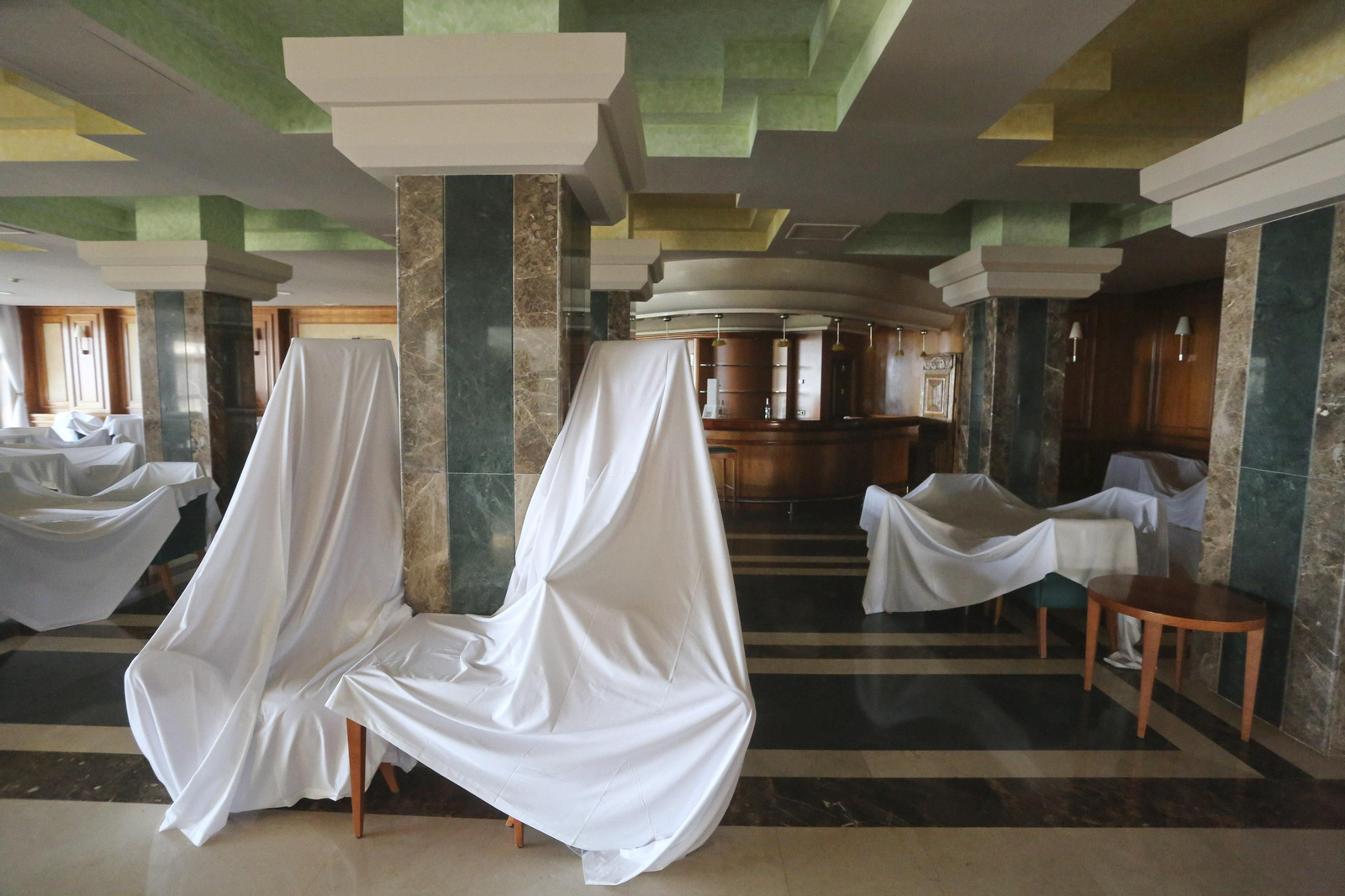 Sábanas blancas visten el hotel Amaragua de Torremolinos, cerrado por el coronavirus, en fotos