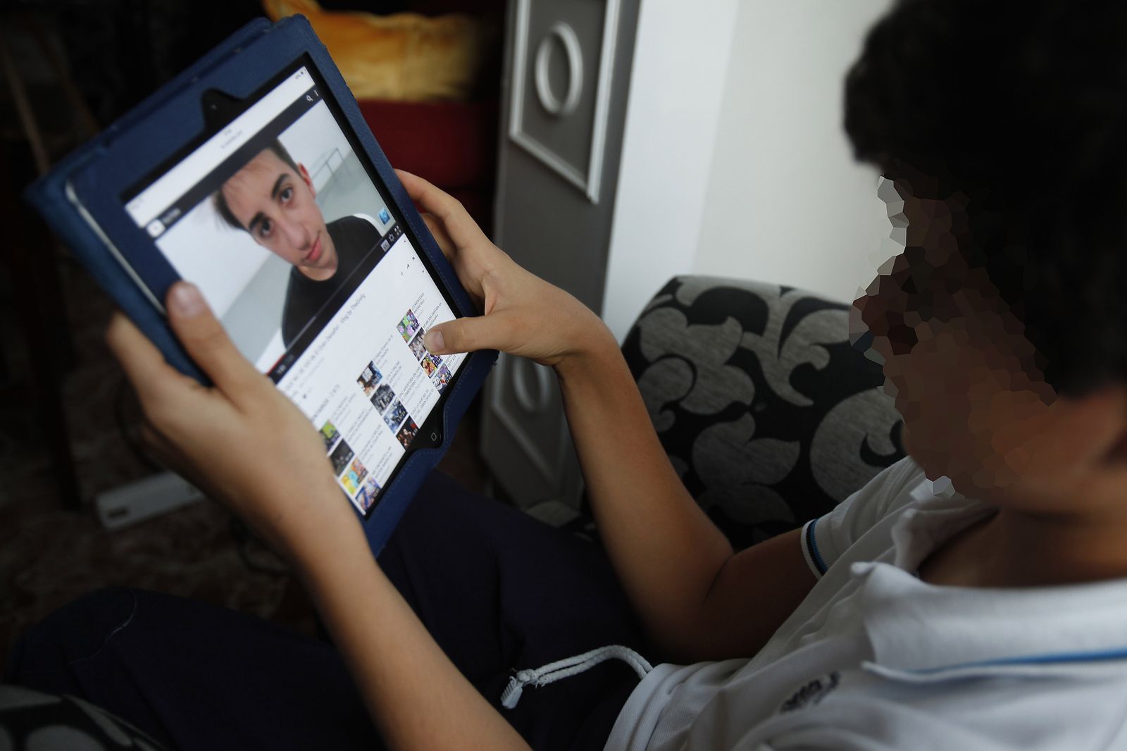Un niño observa un dispositivo electrónico.