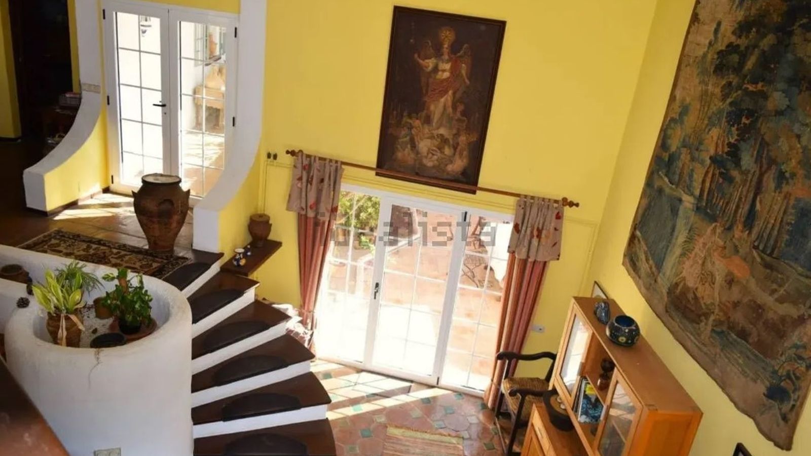 Vista interior desde la planta superior, con acceso a terrazas y salida directa al patio central de la casa.