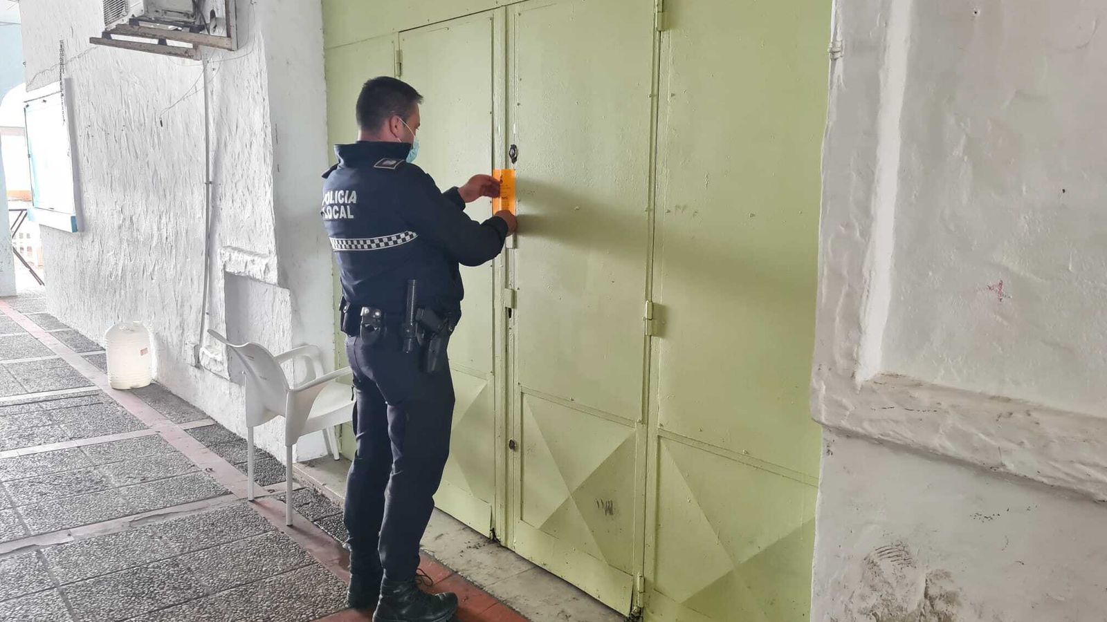 Un agente de policía precintando un local.