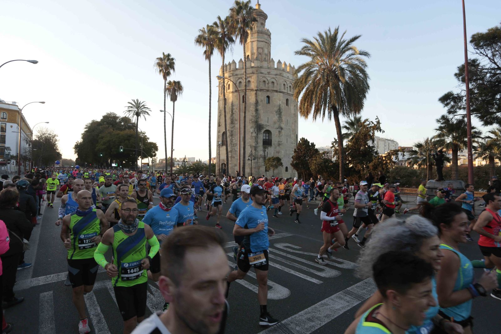 Corredores de la maratón de Sevilla, a su paso por la Torre del Oro.