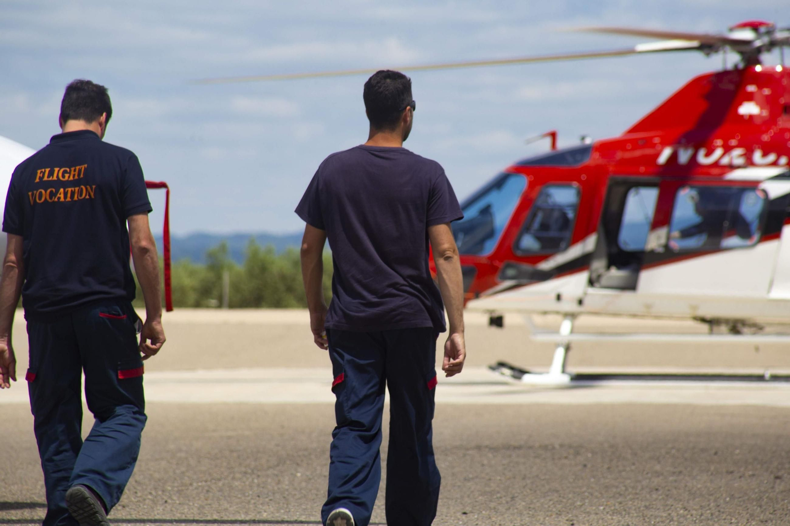 Dos hombres caminan hacia un helicóptero.