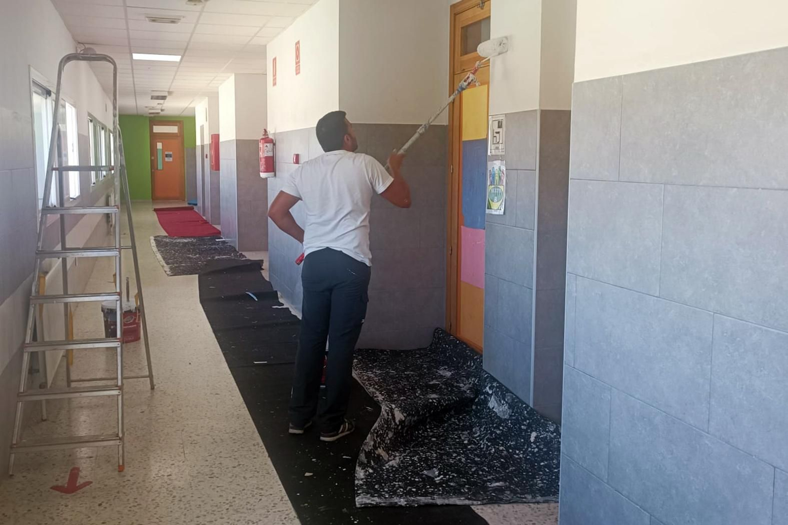 Un operario trabaja en el mantenimiento de uno de los centros de San Juan del Puerto antes del comienzo del nuevo curso.