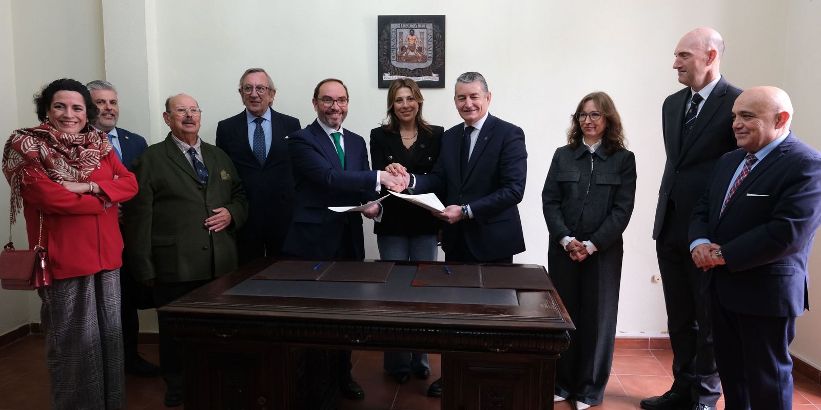 Firma del acuerdo en la misma mesa utilizada por Blas Infante y una réplica del escudo aprobado.