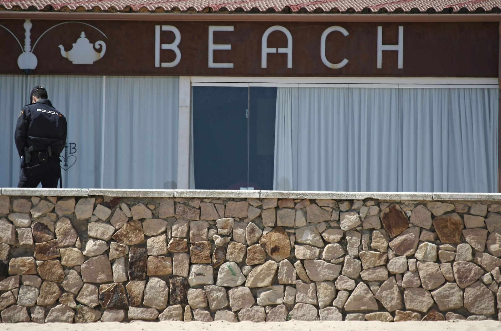 Un policía custodia uno de los locales registrados en la operación .