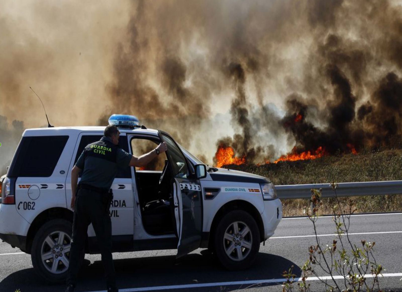 La Guardia Civil corta el tráfico ante la cercanía de las llamas en el incendio del arroyo Pedraza, en Ayamonte, el pasado junio.