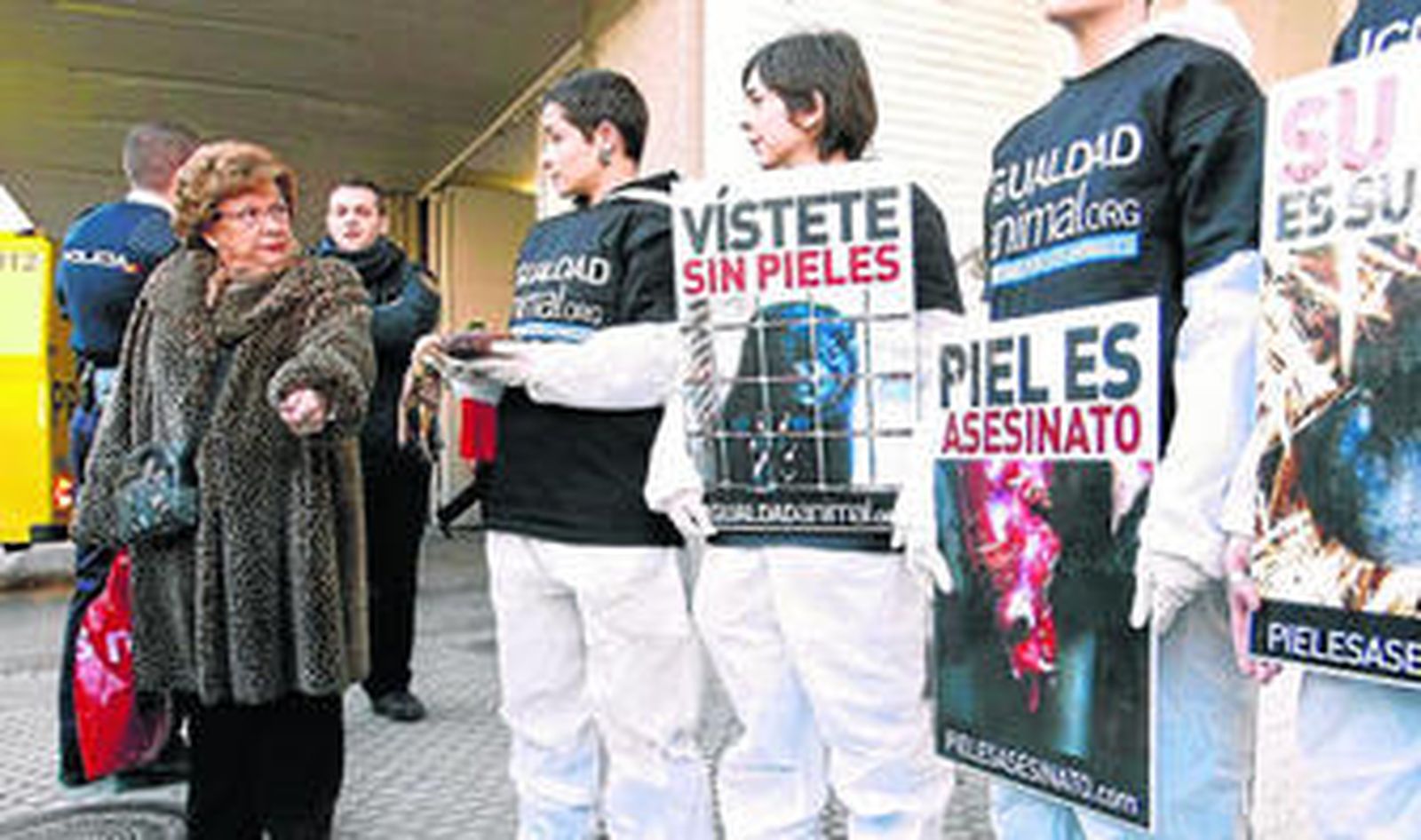 Los activistas defensores de los aimales hablan con una mujer que lleva un abrigo de piel, ayer por la mañana.