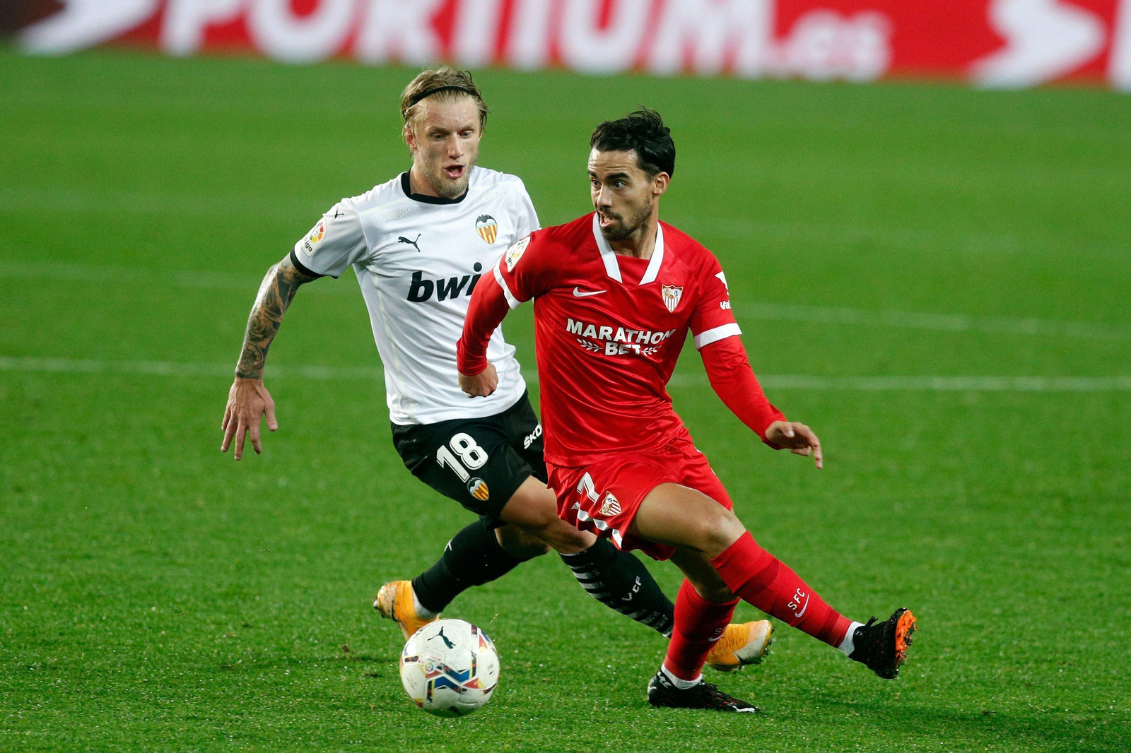 Suso busca una salida a la jugada ante el acoso de Wass.