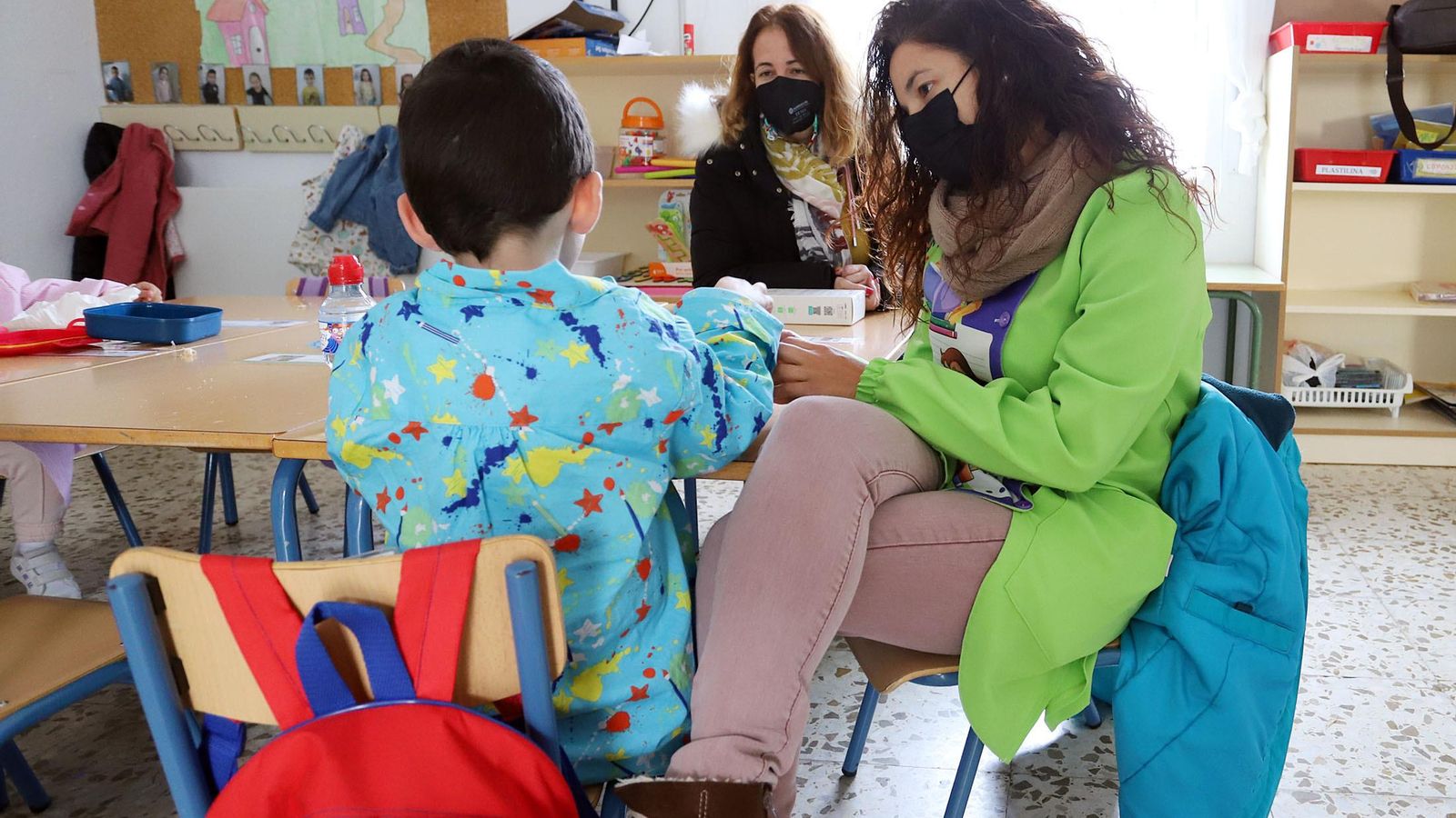 Una docente enseña a su alumno sentada junto a él, la cercanía es un plus.