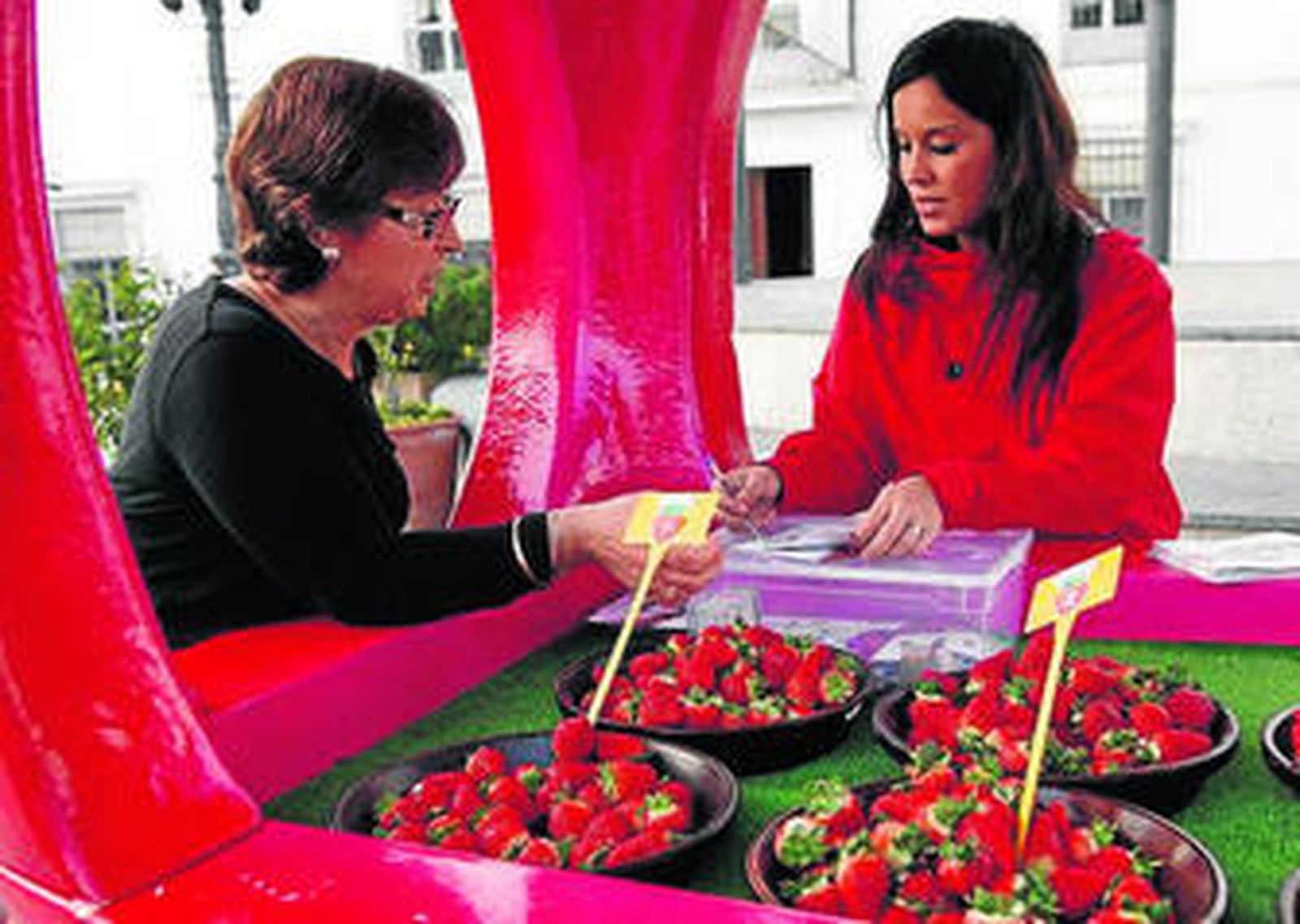 1 y 2. La degustación es el objetivo de la campaña. Pueden hacerla mayores y menos pequeños. 3. Los ciudadanos cuentan con varios platos de fresa, entre los que tienen que elegir la que más les gusta. 4. Tras probar tienen que emitir su voto y apuntarse para participar en los sorteos. 5. El kiosco está siempre rodeado de gente.