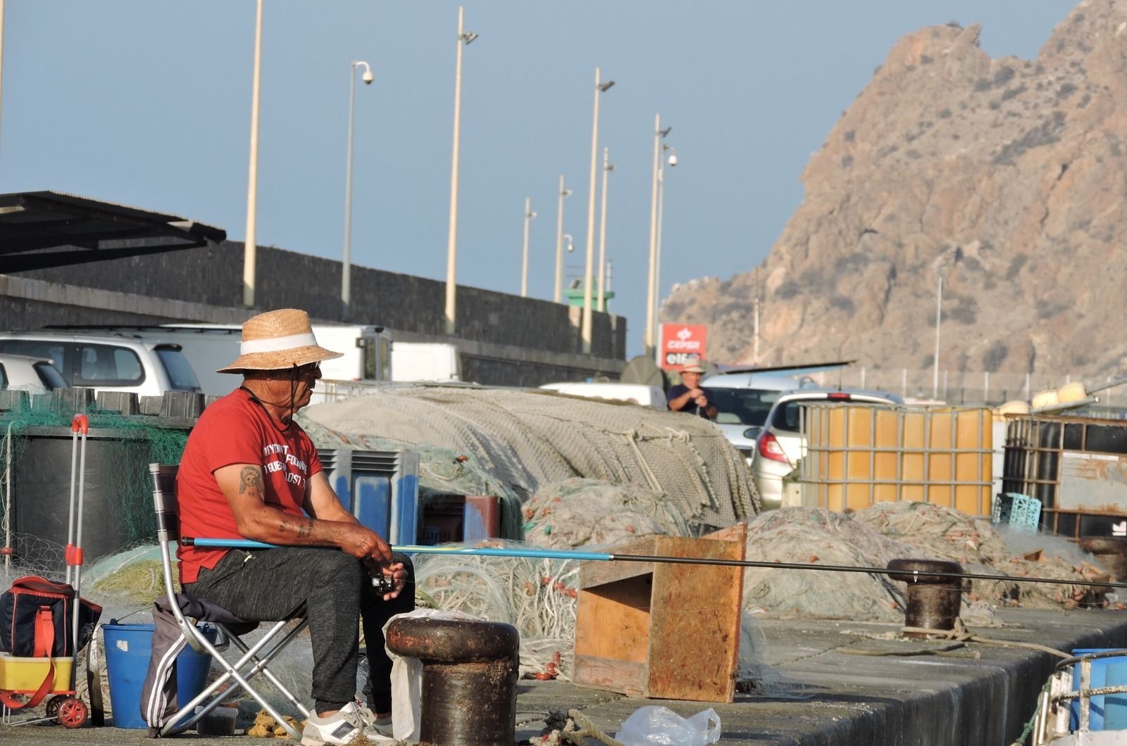 Uno de los vecinos del barrio, mientras pesca en el muelle pesquero del Puerto de Almería.