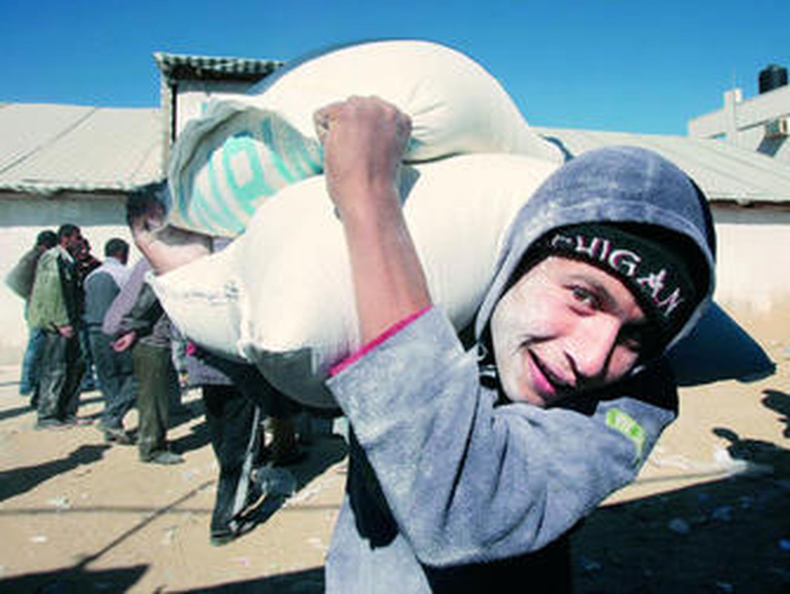 Un trabajador de la Unrwa traslada sacos de harina.