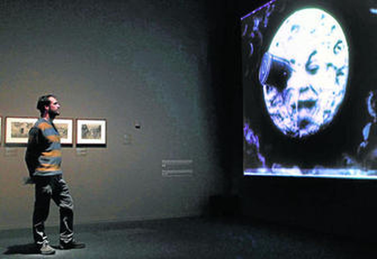 Un visitante observa la proyección de 'Viaje a la luna', de George Méliès.