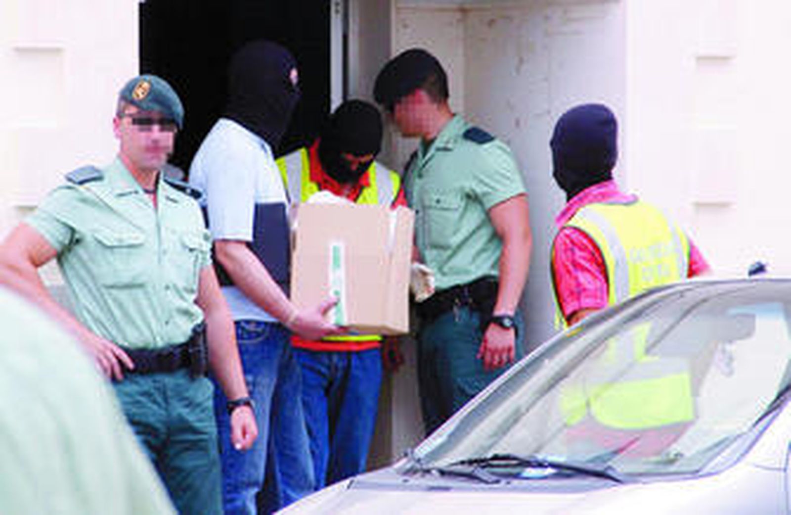 Un agente de la Benemérita saca material del domicilio registrado.