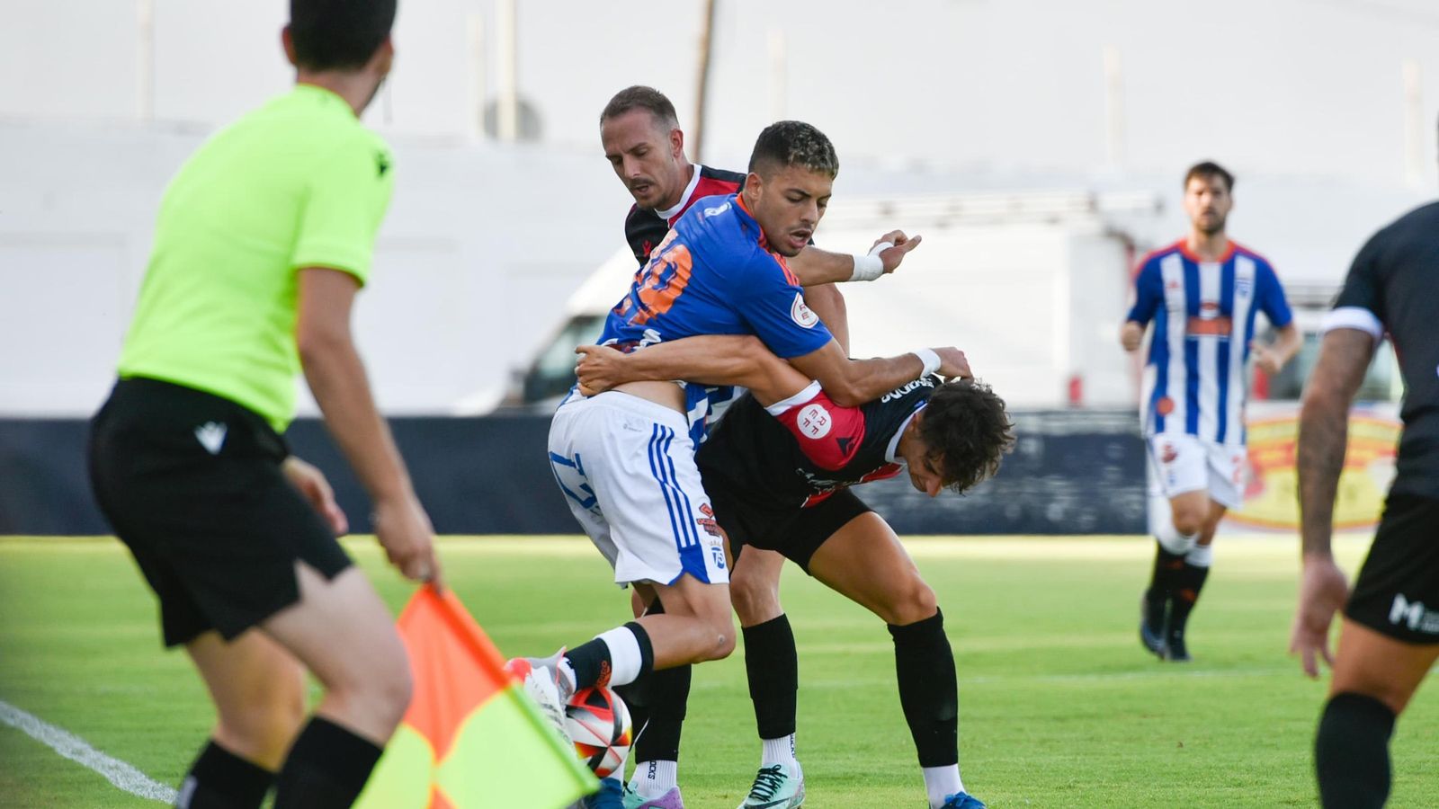 Charaf pugna con dos jugadores del Melilla