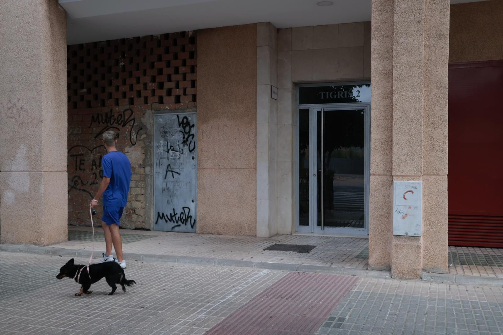 Un hombre pasea su perro por la puerta del número 2 de la calle Tigris, donde ocurrieron los hechos.