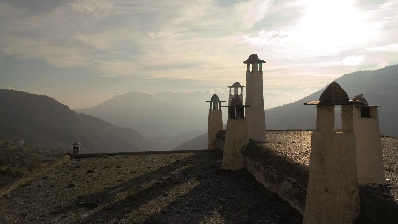 La arquitectura de la Alpujarra destaca por las chimeneas con remate de sombrero, los tinaos y los tejados de launa. La arquitectura de la Alpujarra destaca por las chimeneas con remate de sombrero, los tinaos y los tejados de launa.