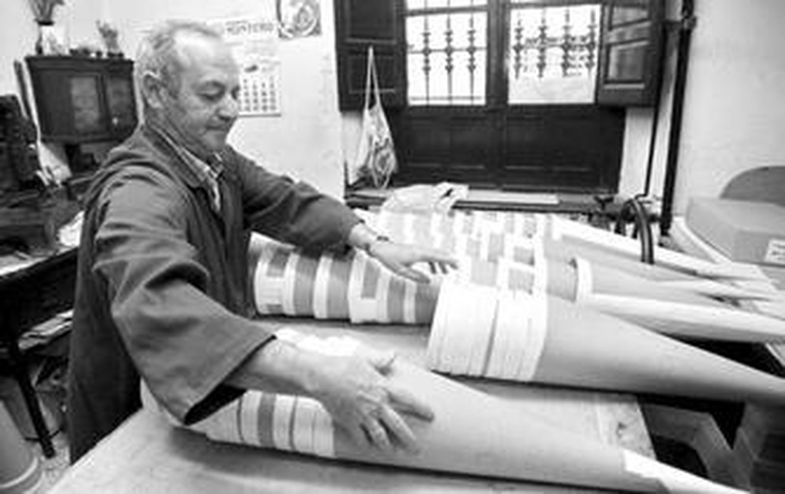 José Arenas coloca los capirotes de cartón en una de las mesas de trabaja que tiene en la trastienda.