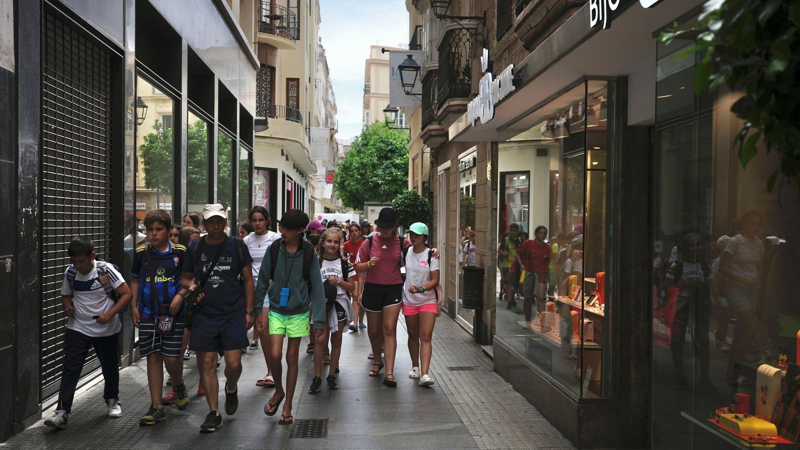 Varios jóvenes pasan por la calle Columela.