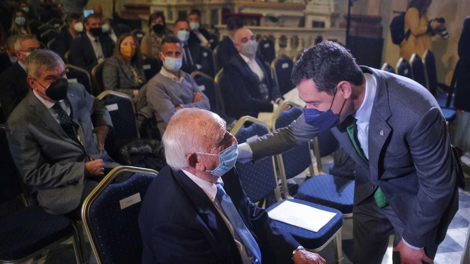 Juanma Moreno saluda al hijo de José María Pemán al comienzo del acto en el Oratorio.