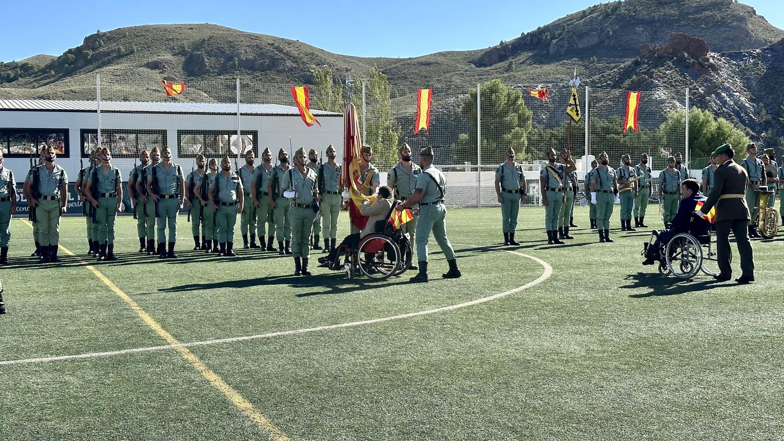 Un vecino en silla de ruedas besa la bandera de España.