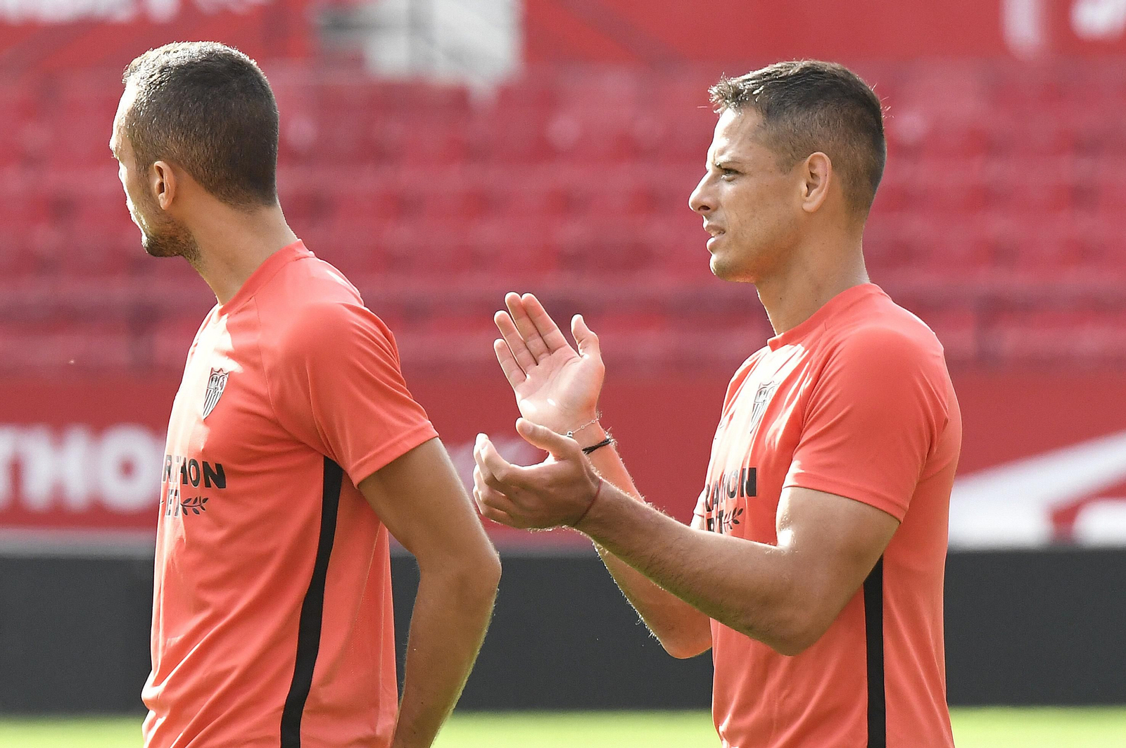 Chicharito aplaude a un compañero junto a Joan Jordán.
