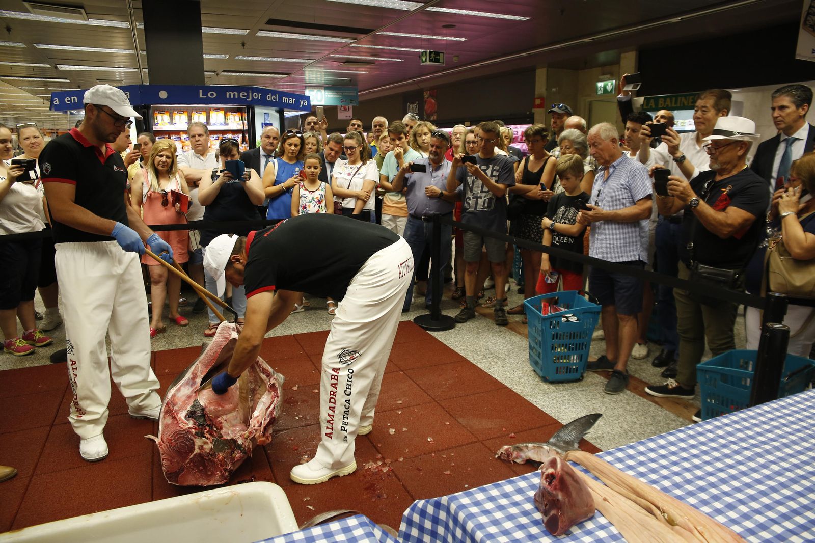 Los maestros cortadores despiezan el atún ante la mirada curiosa de los clientes de El Corte Inglés.