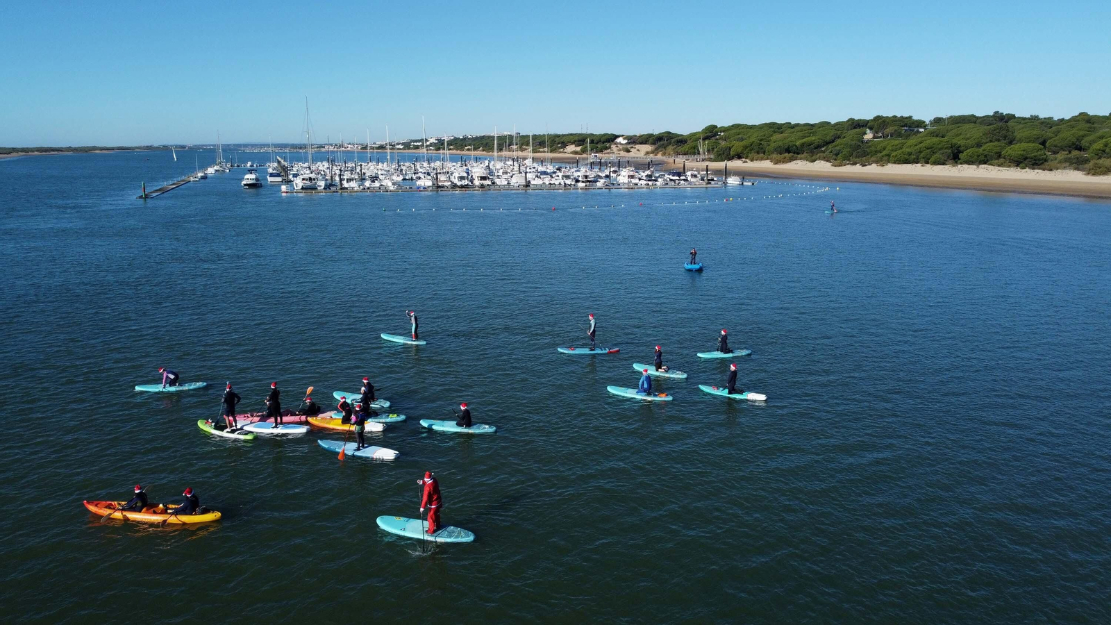 Las mejores imágenes de los Papás Noel que ha cruzado el río Piedras en paddle surf