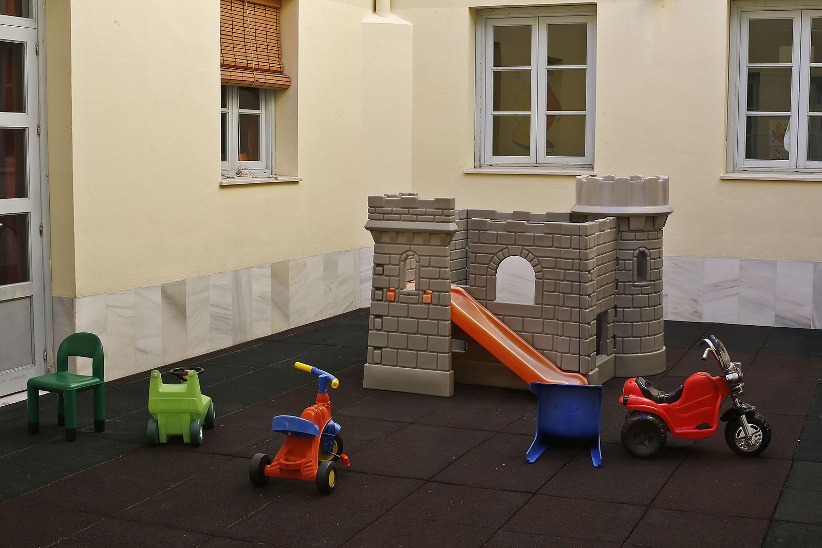 Un castillo y varios juguetes, en el patio interior de la guardería municipal de la calle San Juan de Dios.