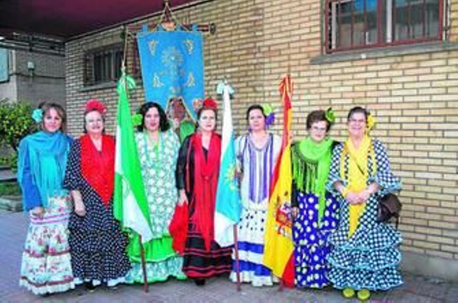 Mujeres vestidas de gitana con el guión de la Cruz de los Ángeles.